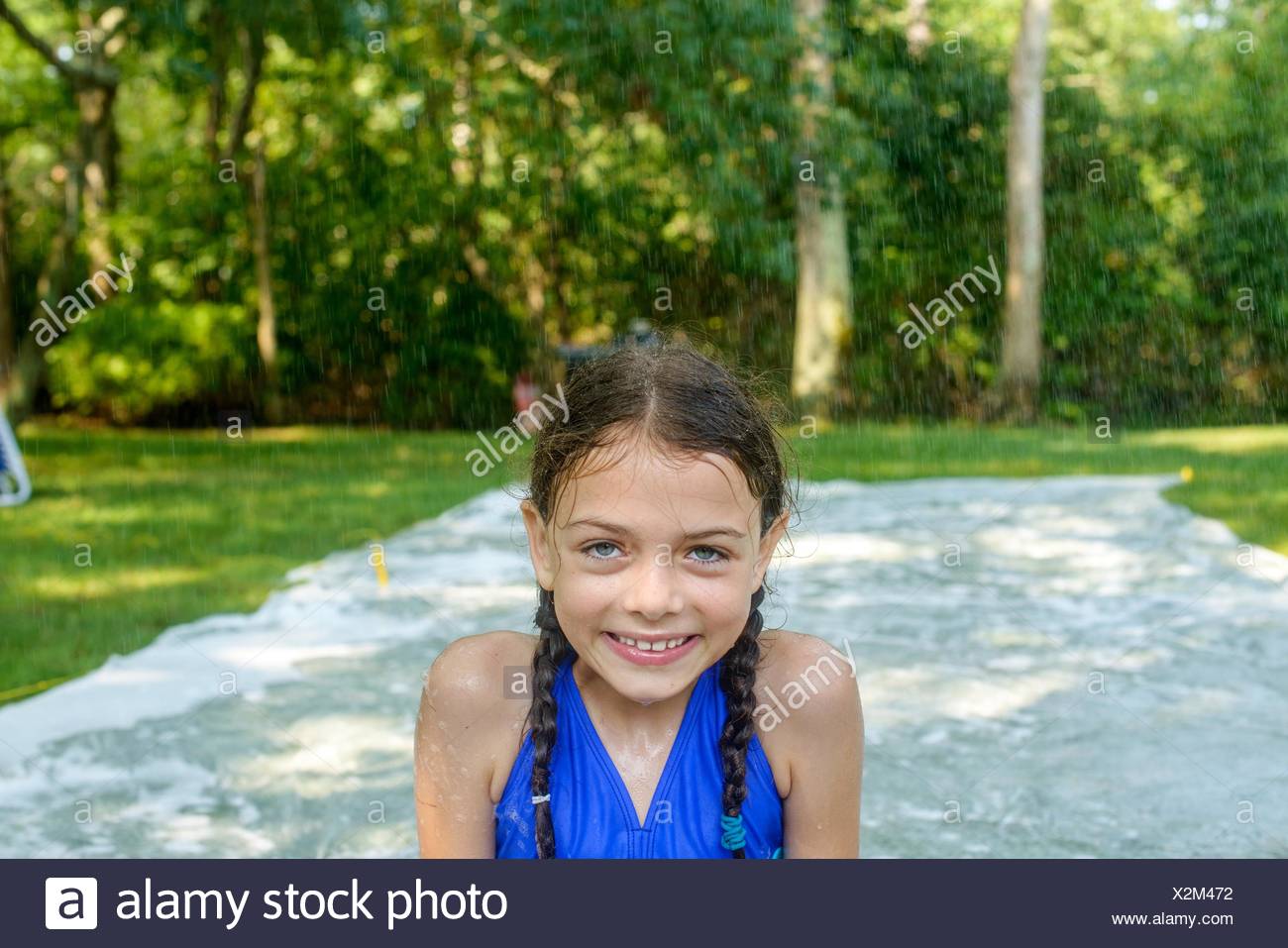 Portrait Of Girl In Garden Slip N Slide Water Mat Behind Her