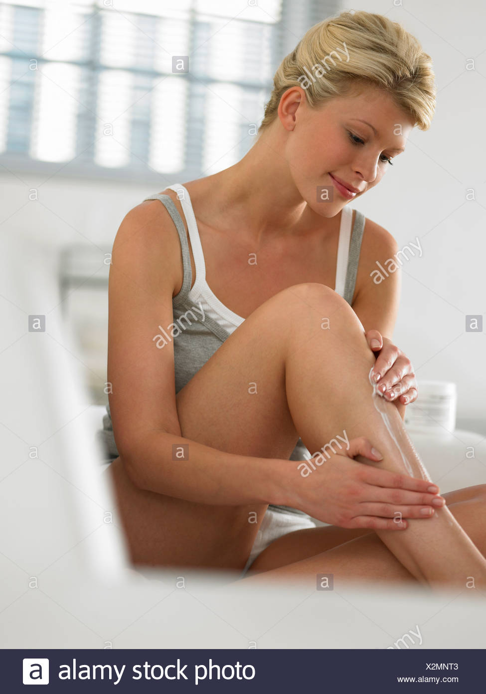 Woman Putting Lotion On Legs Stock Photos & Woman Putting Lotion On