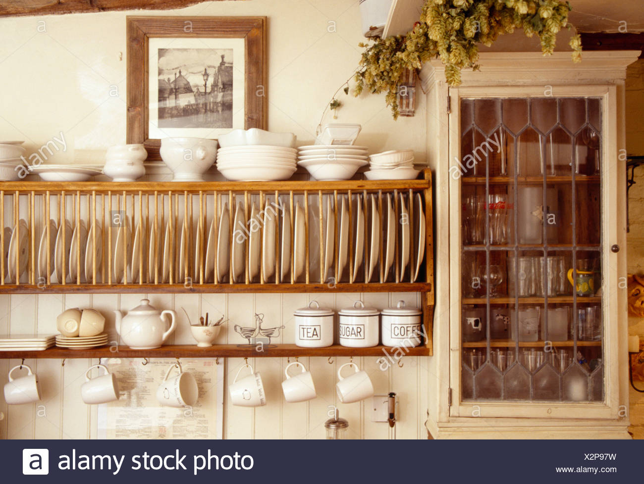 Close Up Of Cream Bowls On Wooden Plate Rack Beside Small Wall Cupboard In Cottage Kitchen Stock Photo Alamy