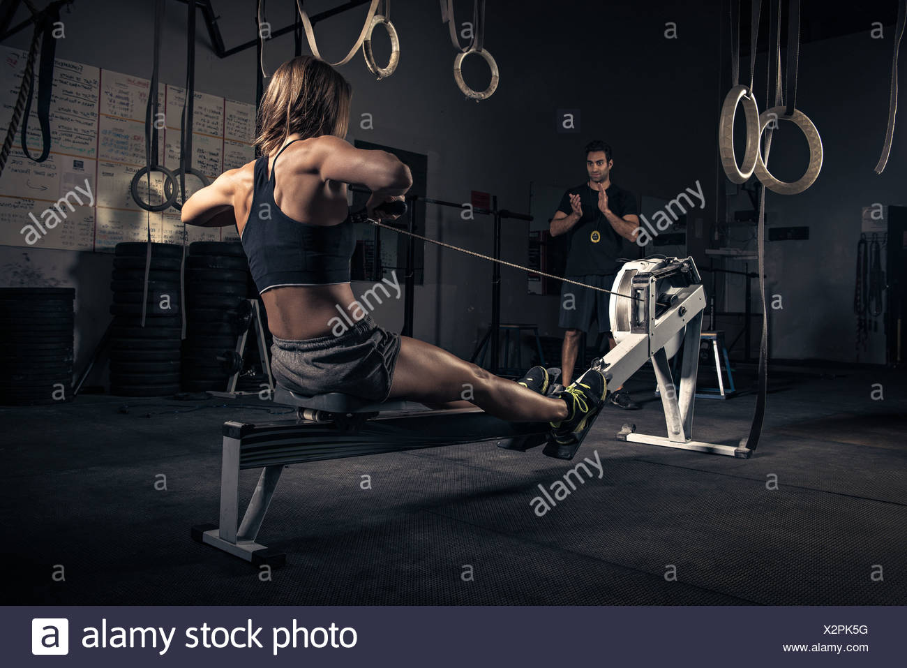Woman Using Rowing Machine In High Resolution Stock Photography and ...