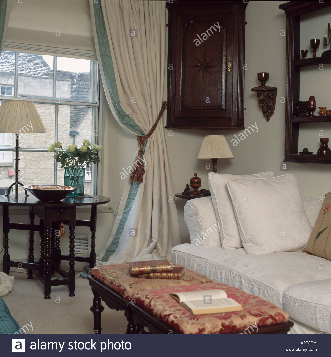 Antique Corner Cupboard And White Curtains With Blue Trimming In