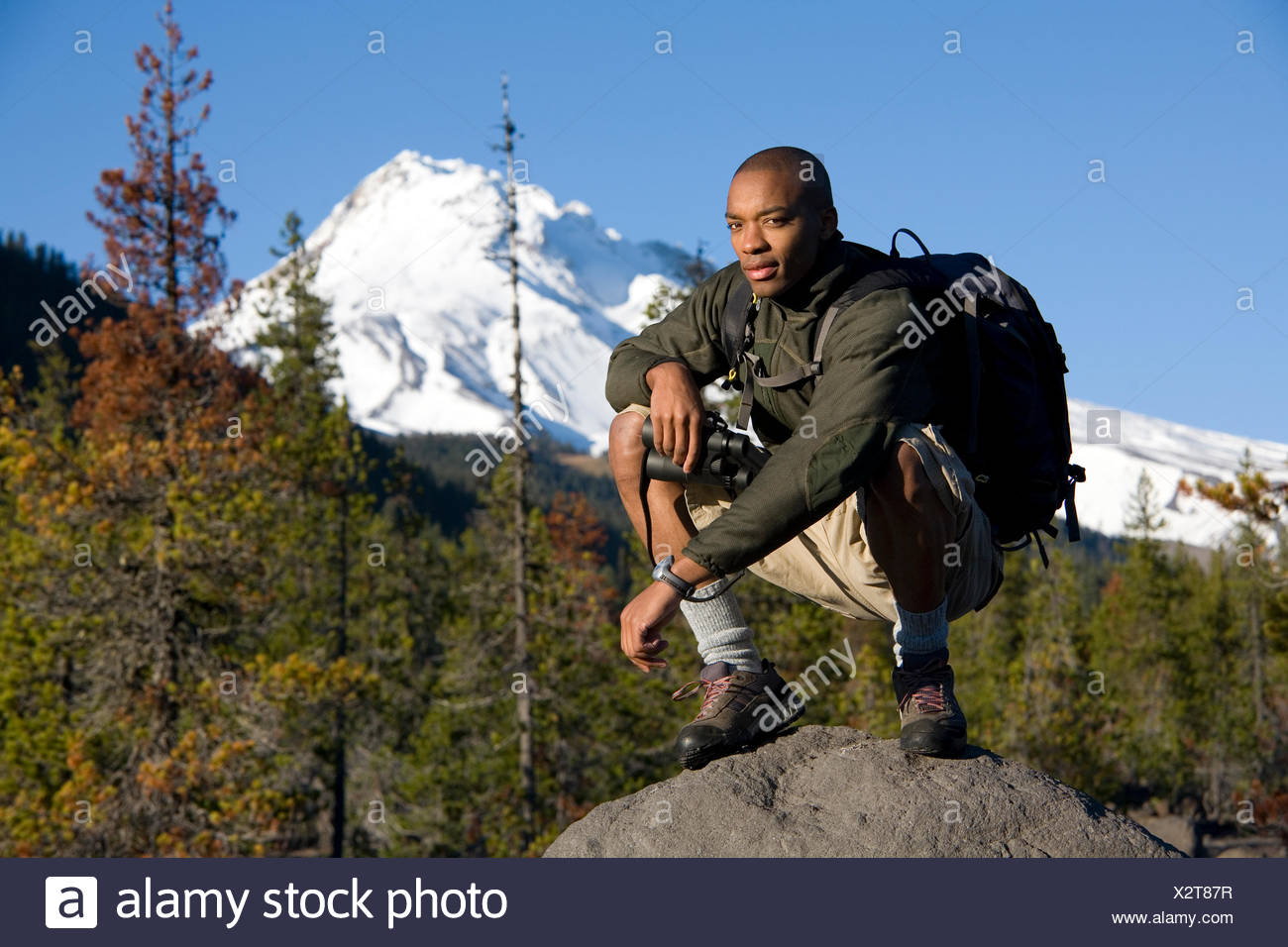 African American Man Cupid Alexander Squats On Rock In Forest During Hike Near Mt Hood In The Cascade Mountains Oregon Stock Photo Alamy