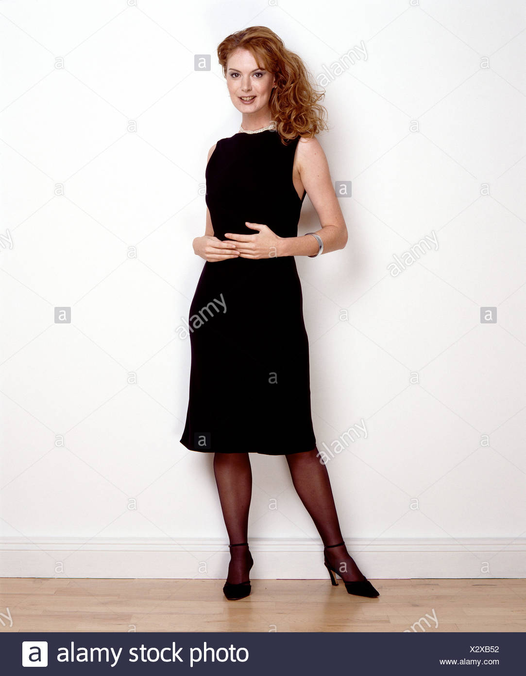 Female Shoulder Length Dark Blonde Curly Hair Wearing Black Shift