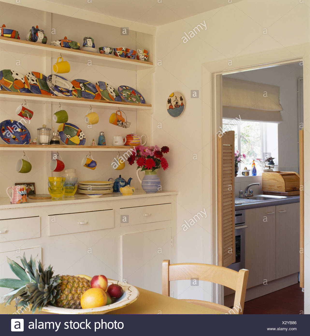 Colorful Pottery Plates And Cups On Fitted Dresser Shelves In