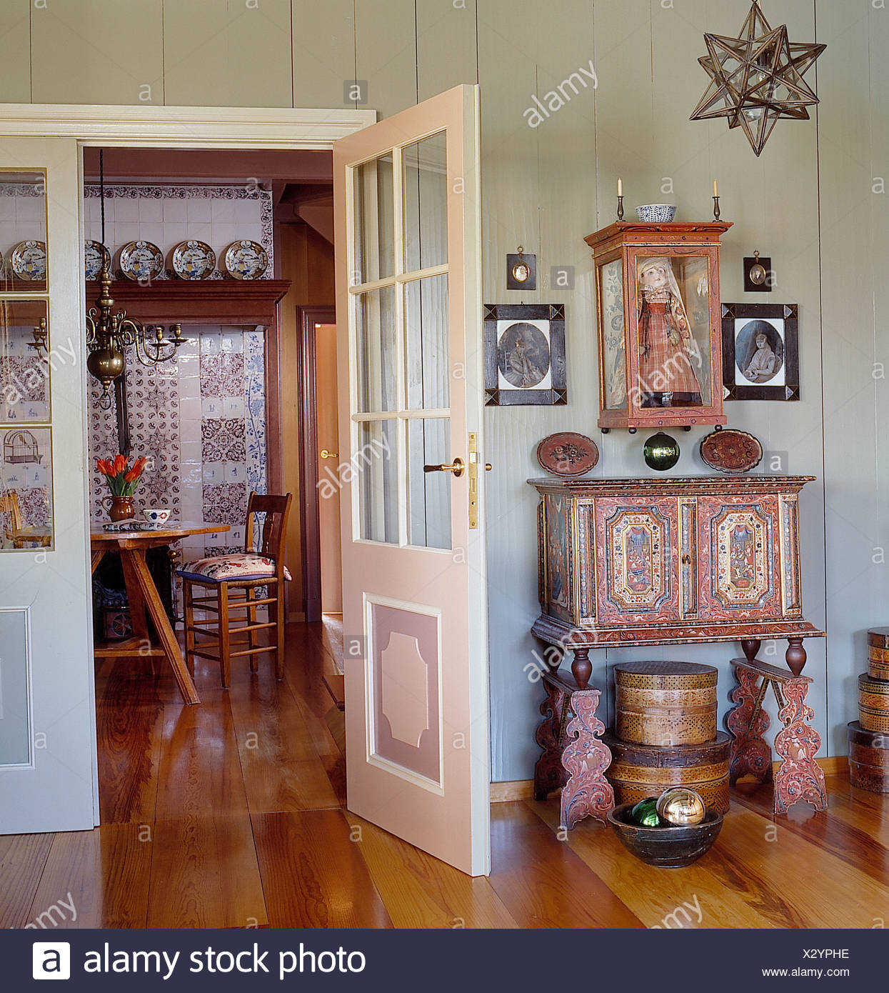 Doll In Glass Case Above Painted Dutch Style Cabinet And Wooden