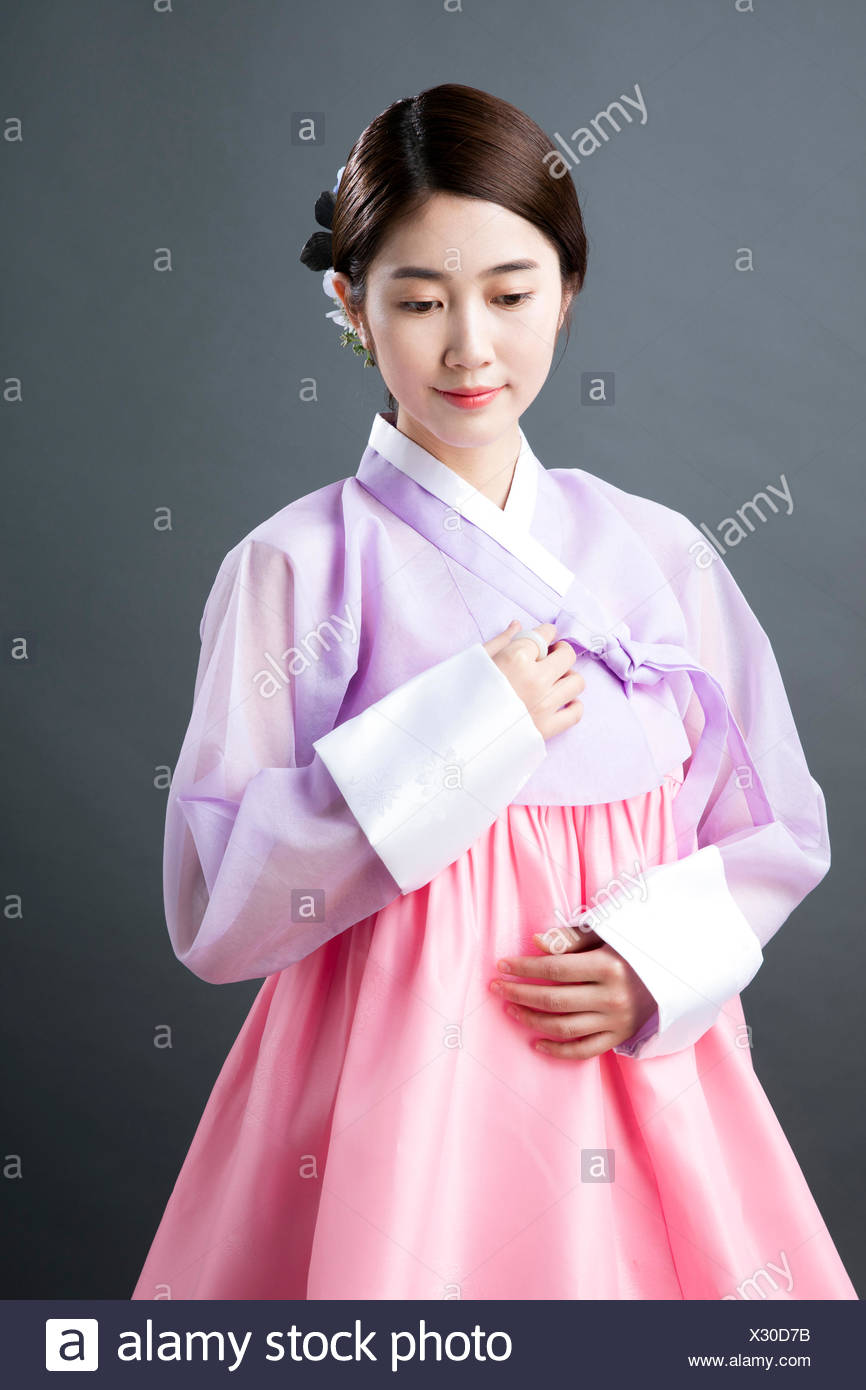 Young woman in traditional Korean clothes looking down Stock Photo