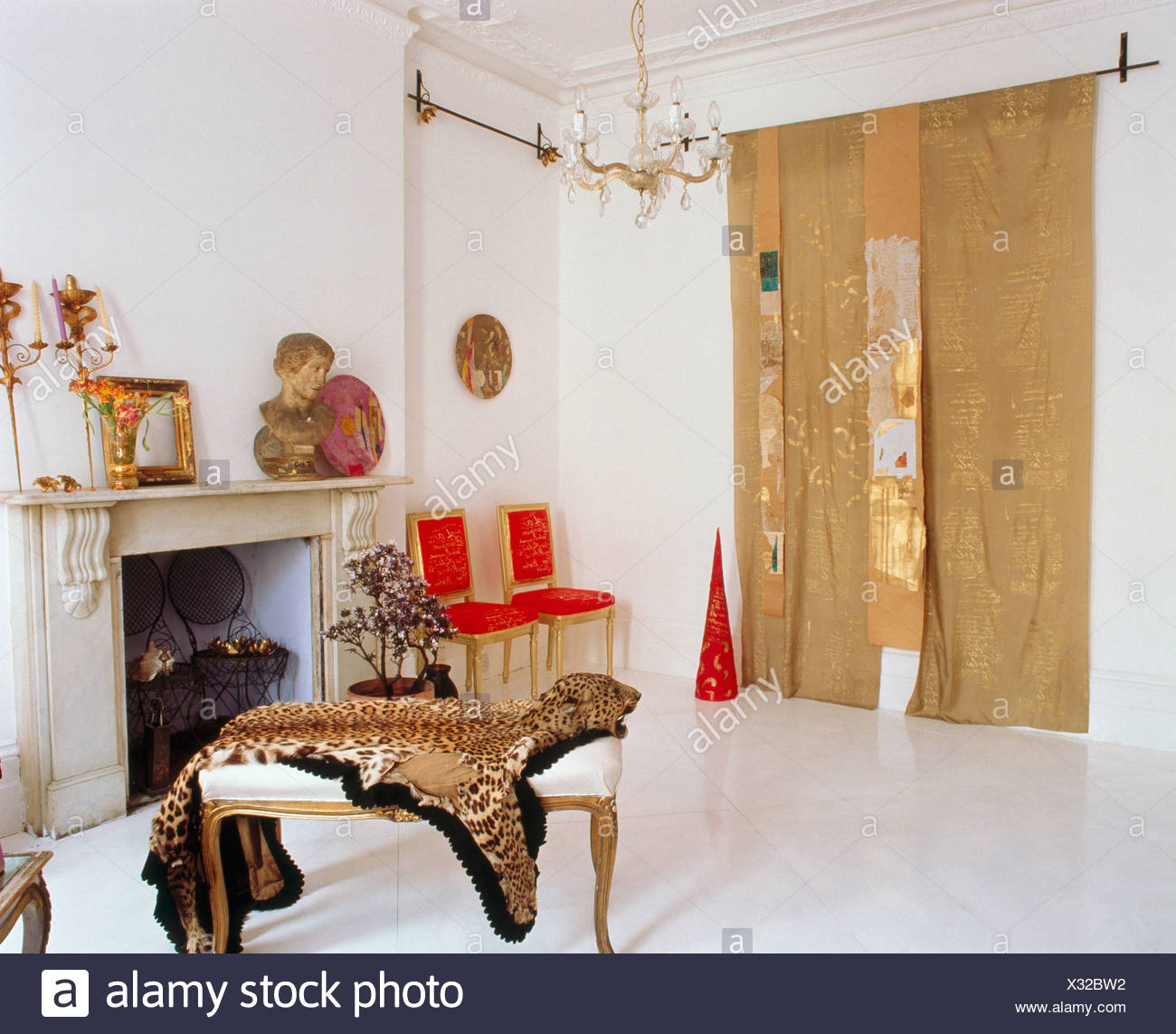 Faux Tiger Skin On Stool In Front Of Fireplace In White Bedroom