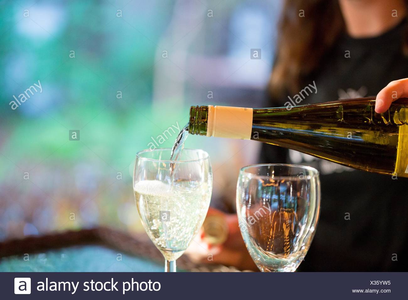 Bartender Pouring White Wine Into A Glass At A Wedding Reception