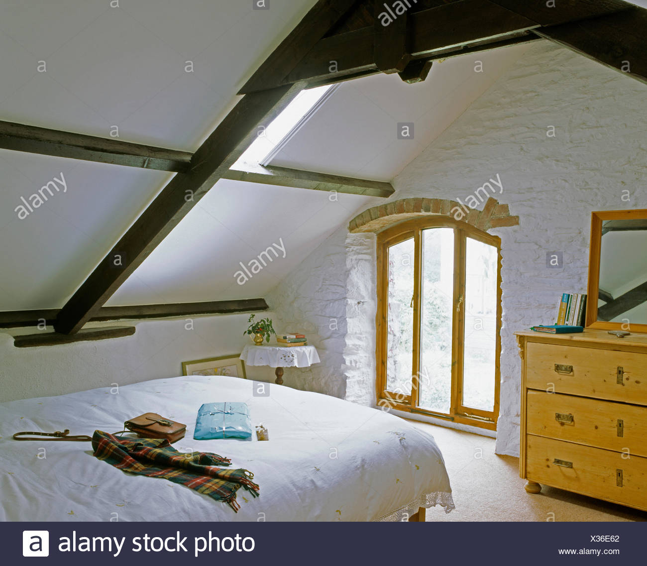 White Painted Exposed Stone Wall And Black Beams Cottage Bedroom
