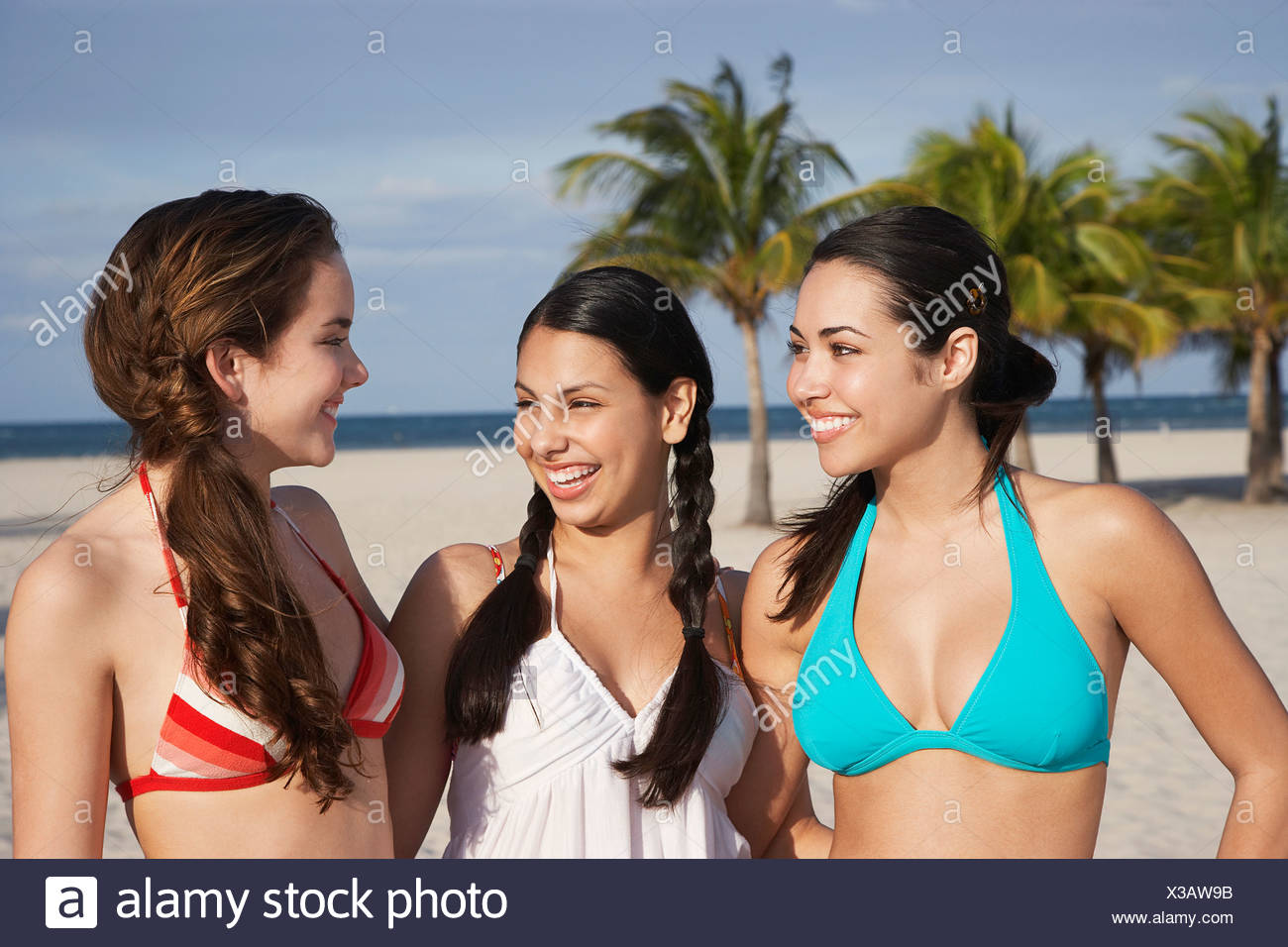 Three teenage girls (16-17) wearing bikinis, standing on beach, portrait  Stock Photo - Alamy