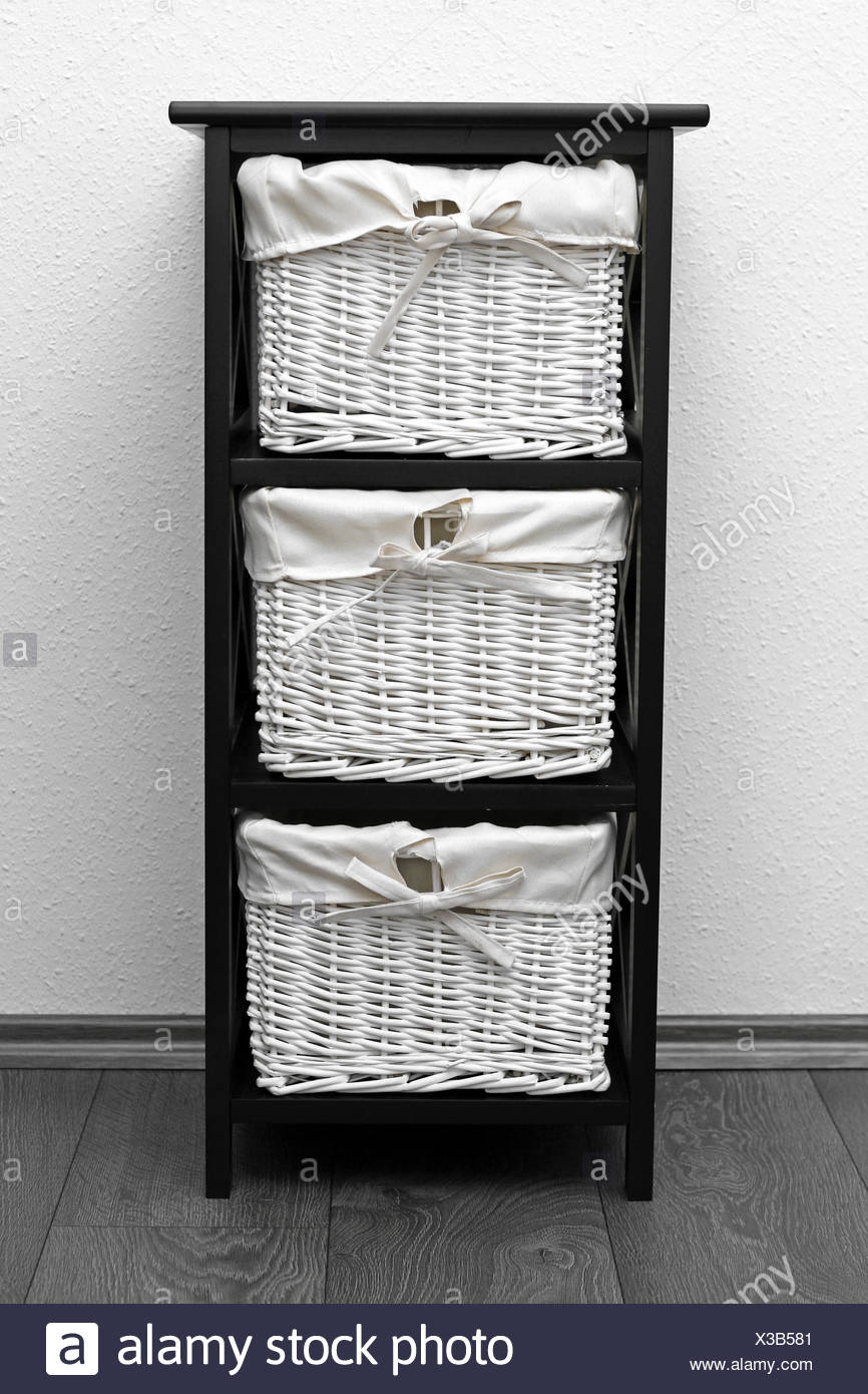 storage shelf baskets on Brown Shelf With Wicker Baskets At White Wall Stock Photo Alamy