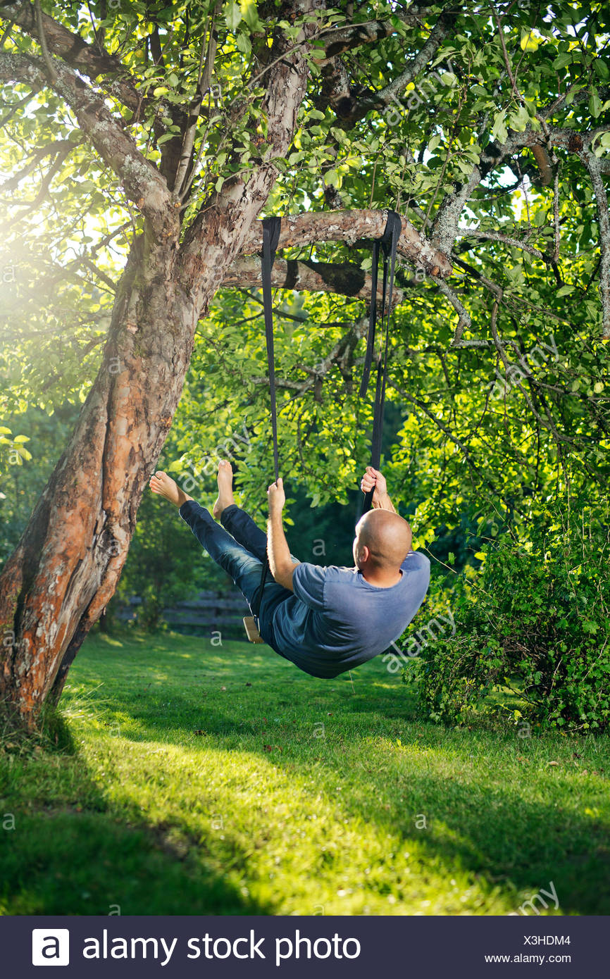 Man Swinging From Tree