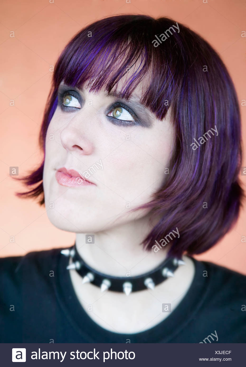 Alternative Young Woman With Purple Hair Looking Up To The Right