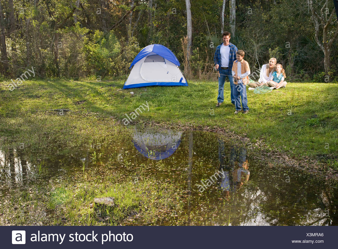 Family Having Fun On Camping Trip Fishing By Tent Stock Photo Alamy