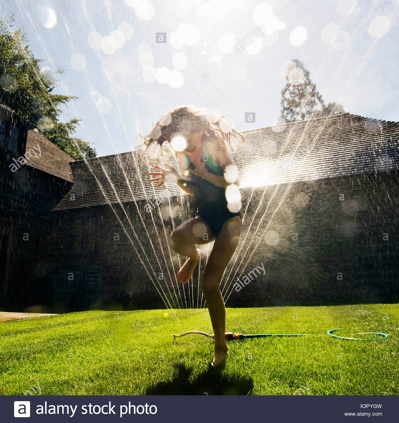 Girl Running Through Sprinkler Stock Photos & Girl Running Through