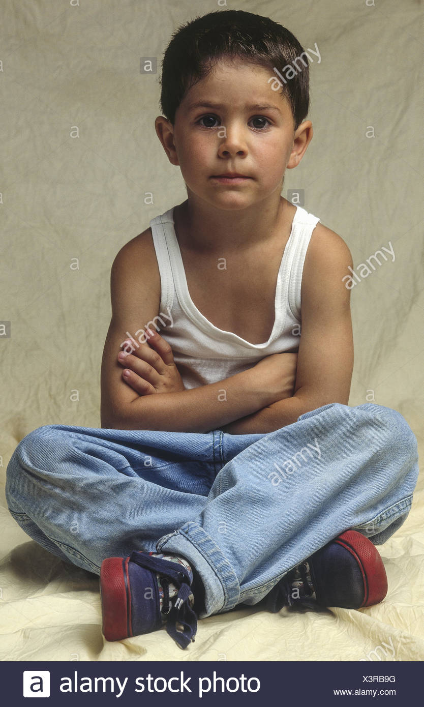 Kleiner Junge, sitzt im Schneidersitz, verschraenkte Arme (model-released) Stock Photo