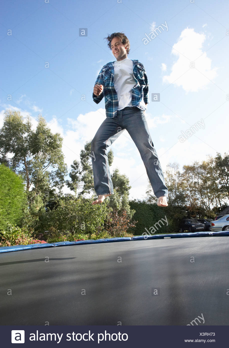 Young Man Jumping On Trampoline Caught In Mid Air Stock Photo Alamy