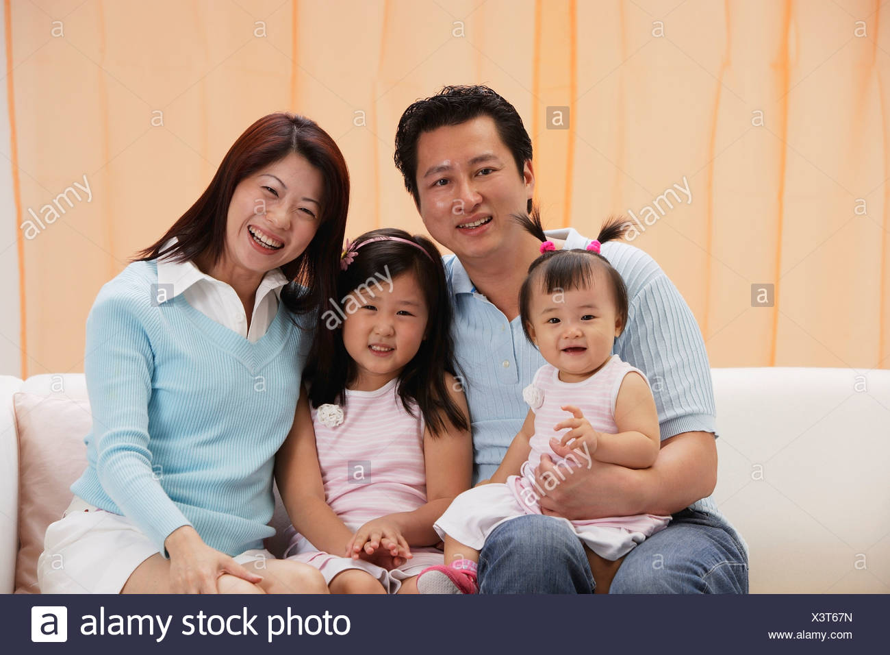 Portrait Of Family Of 4 Mom Dad And Two Daughters Sitting On