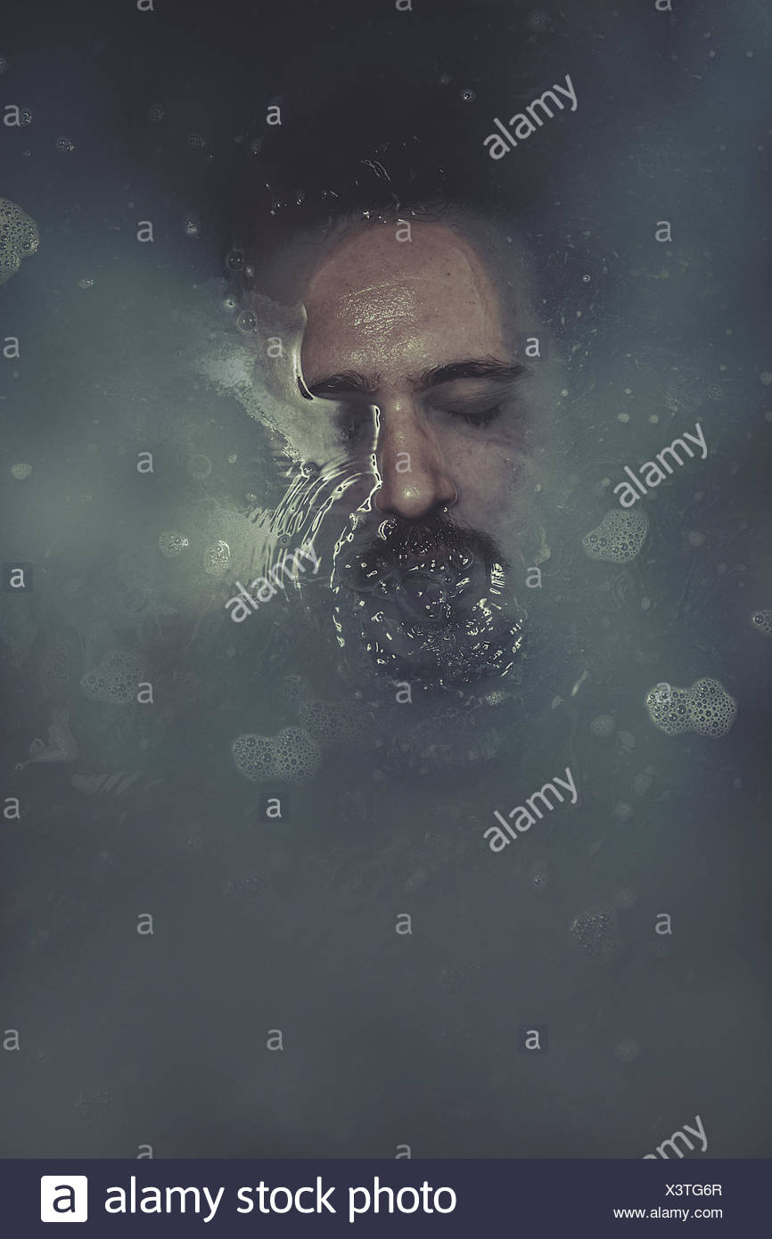 concept suicide, man submerged in blue water Stock Photo