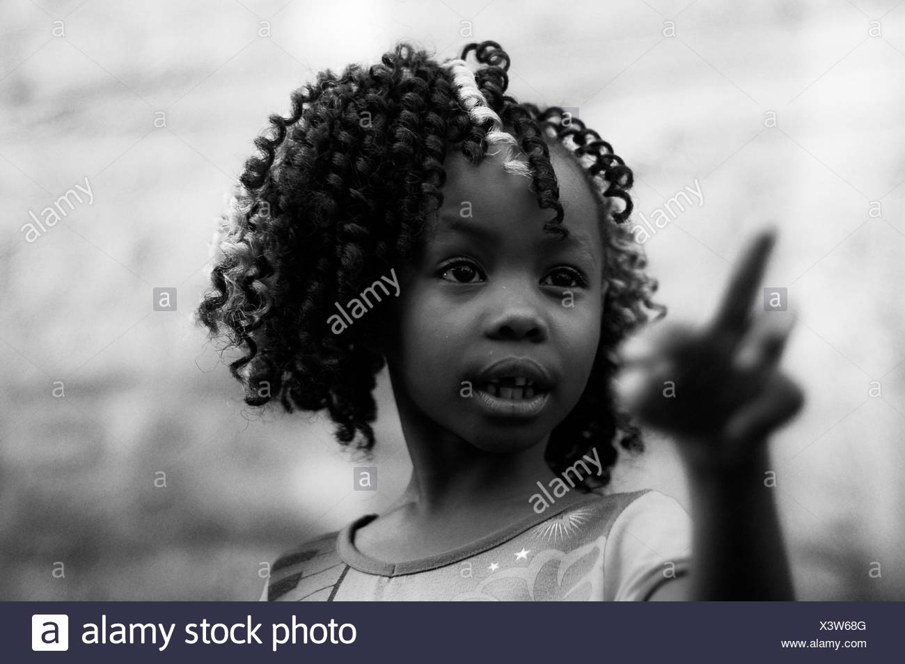 Close Up Of Girl With Frizzy Curly Hair Pointing Outdoors Stock