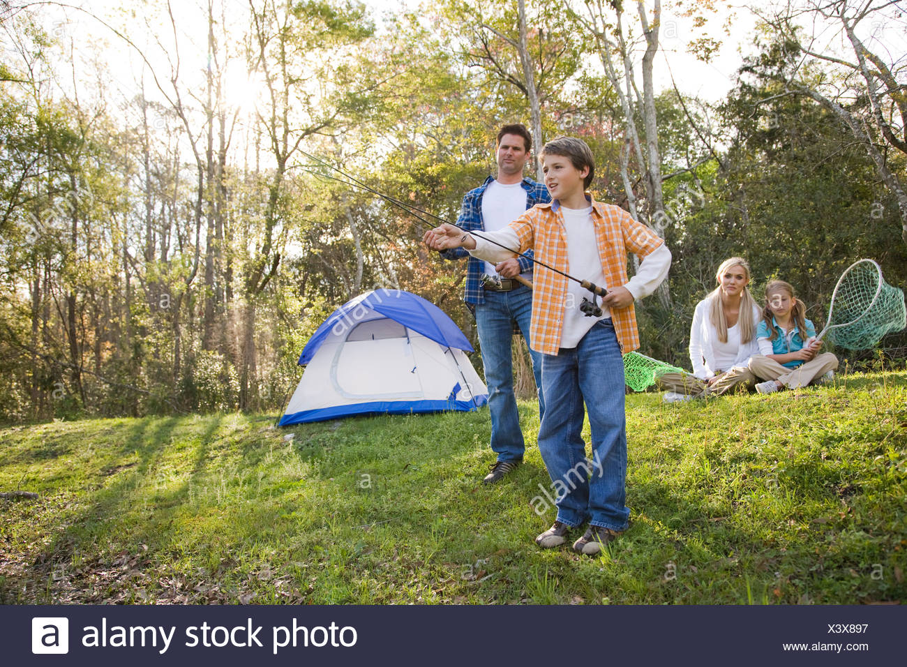 Family On Camping Trip Fishing By Tent Stock Photo Alamy