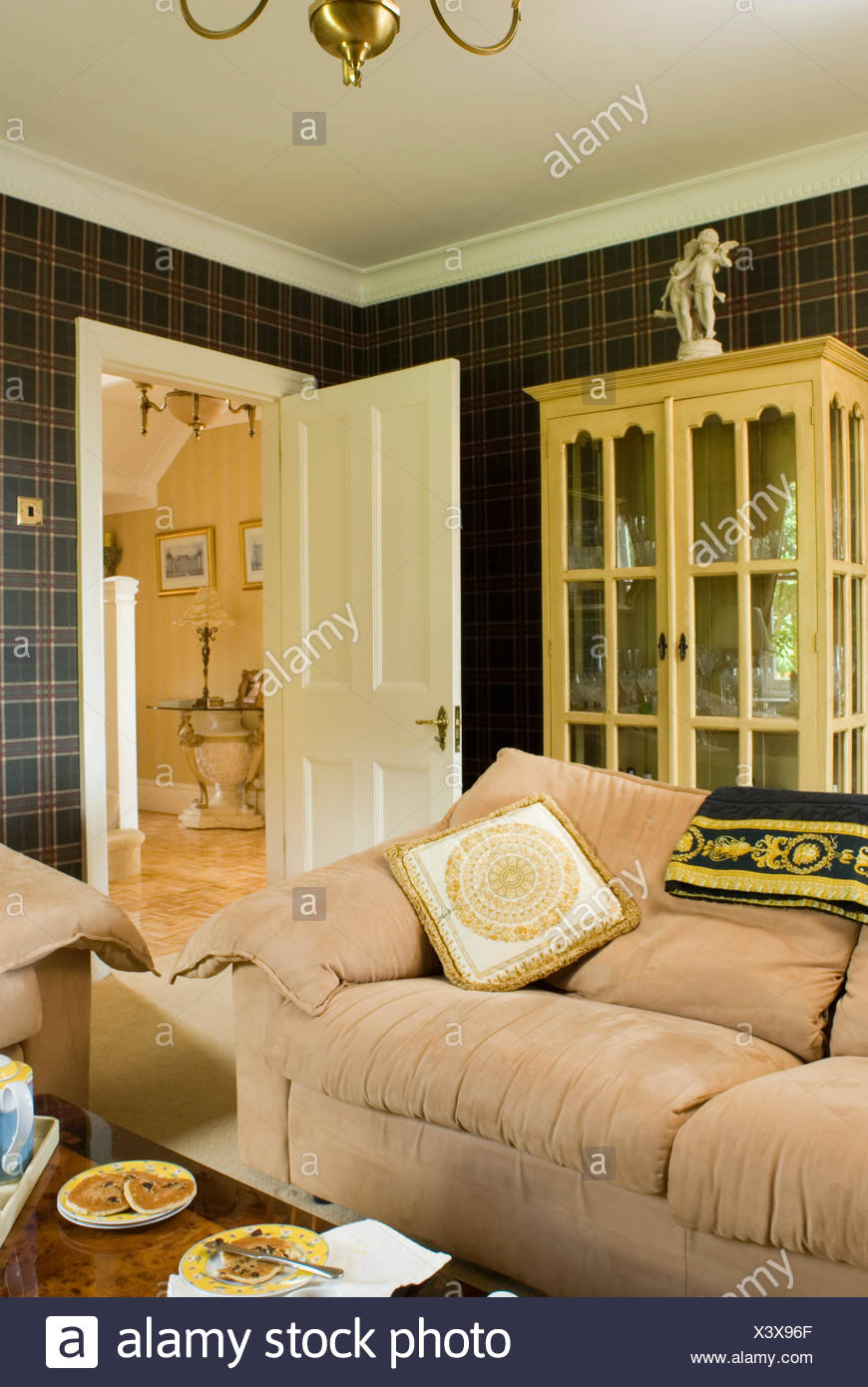 Cream Velour Sofa In Front Of Glass Fronted Cupboard In
