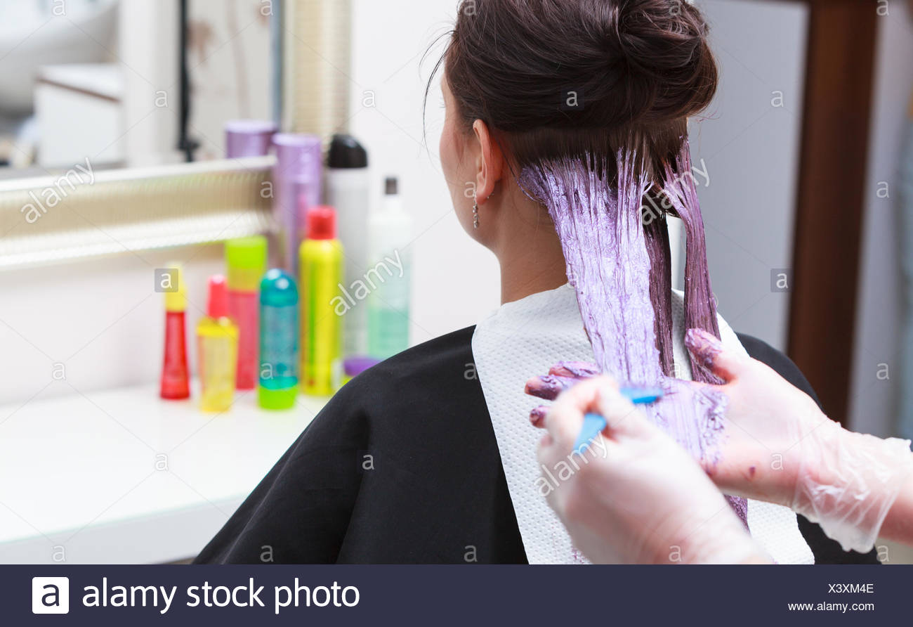 Professional Female Hairdresser Applying Color To Female Customer