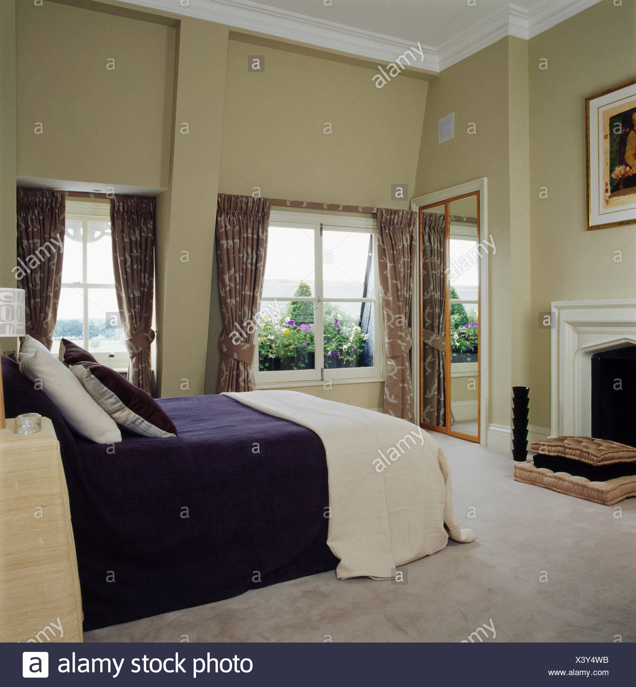 Cream Throw And Dark Blue Bed Cover On Bed In Large Loft