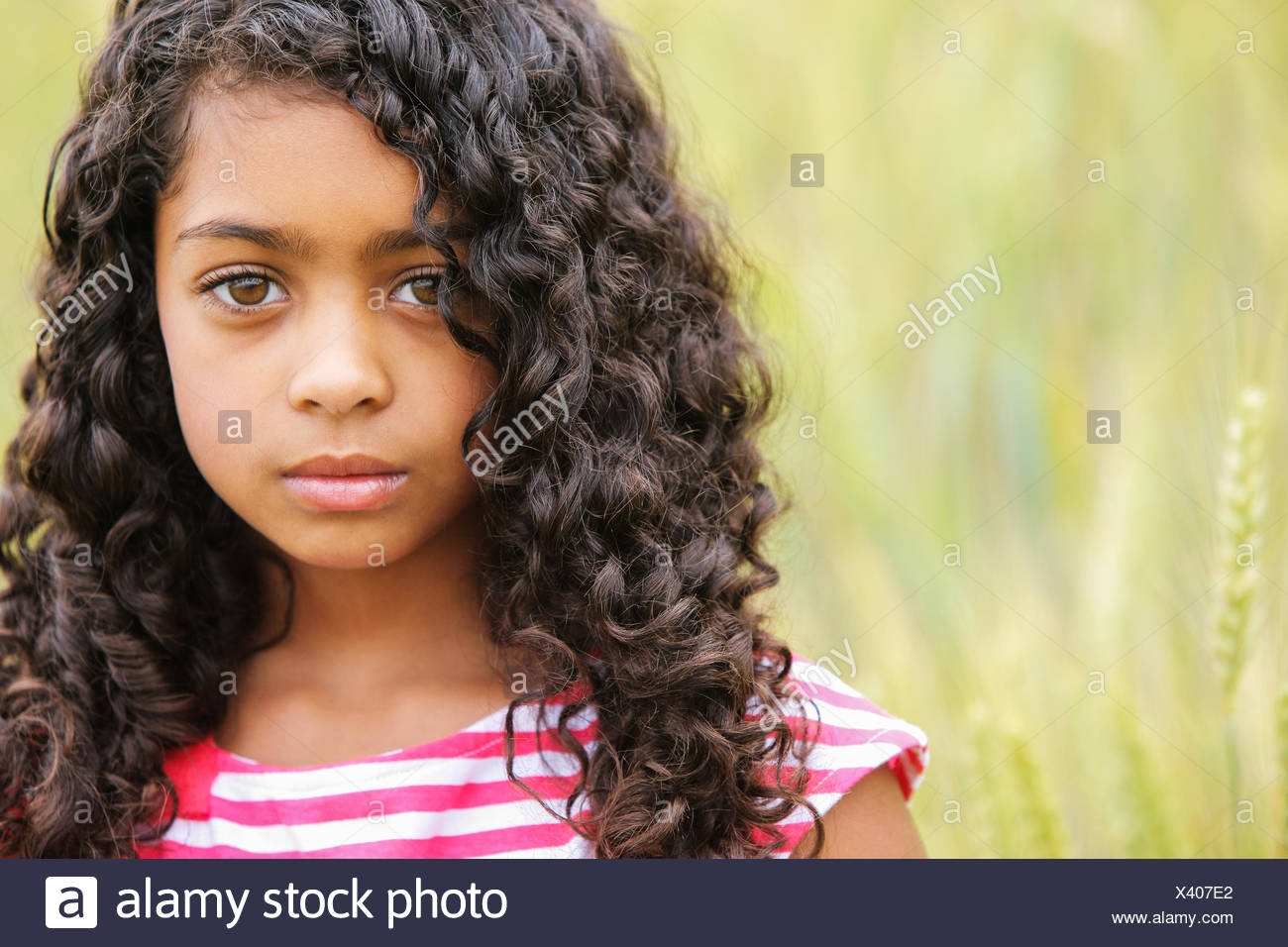 Portrait Of A Young Girl With Dark Curly Hair And Big Brown
