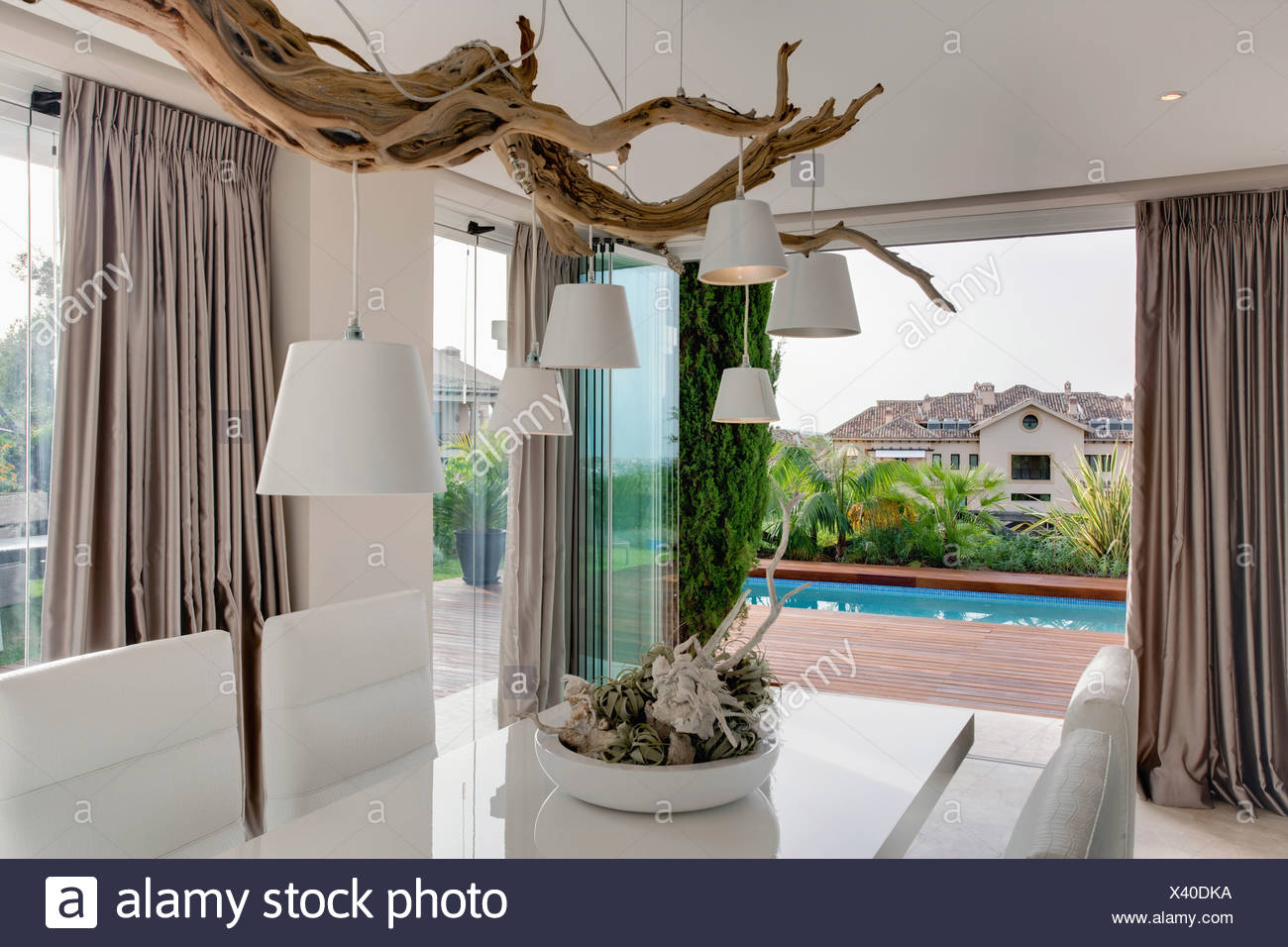 White Lampshades Hanging From Rustic Tree Branch Above Table In