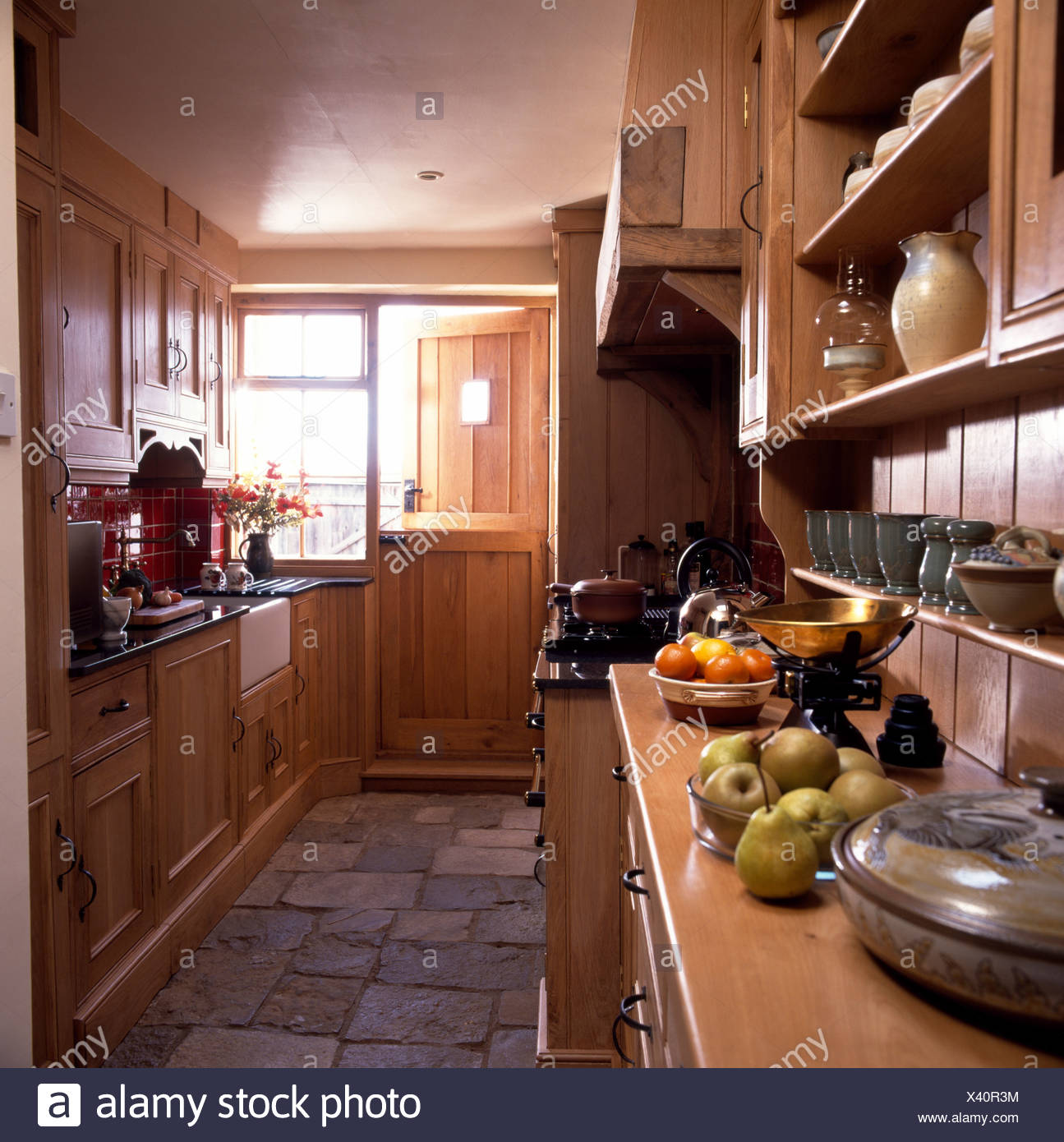 Stone Floor Tiles In Narrow Country Kitchen With Fitted Wooden