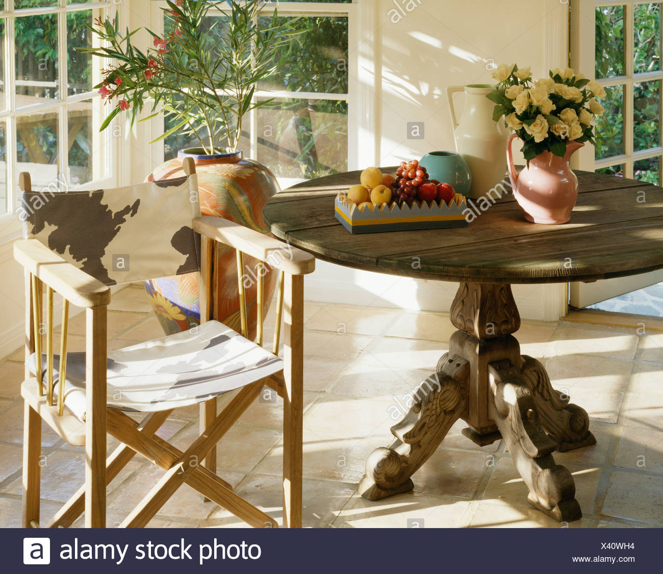 Close Up Of Circular Antique Table With Animal Print Director S Chair In Sunny Dining Room Stock Photo Alamy