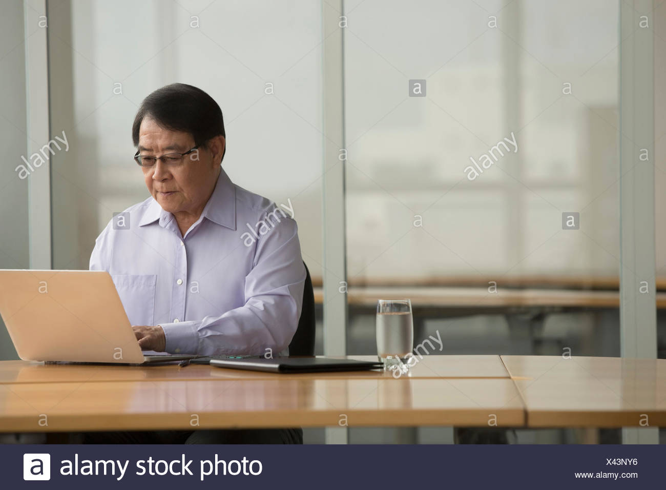 Singapore Senior Businessman Using Laptop At Desk Stock Photo