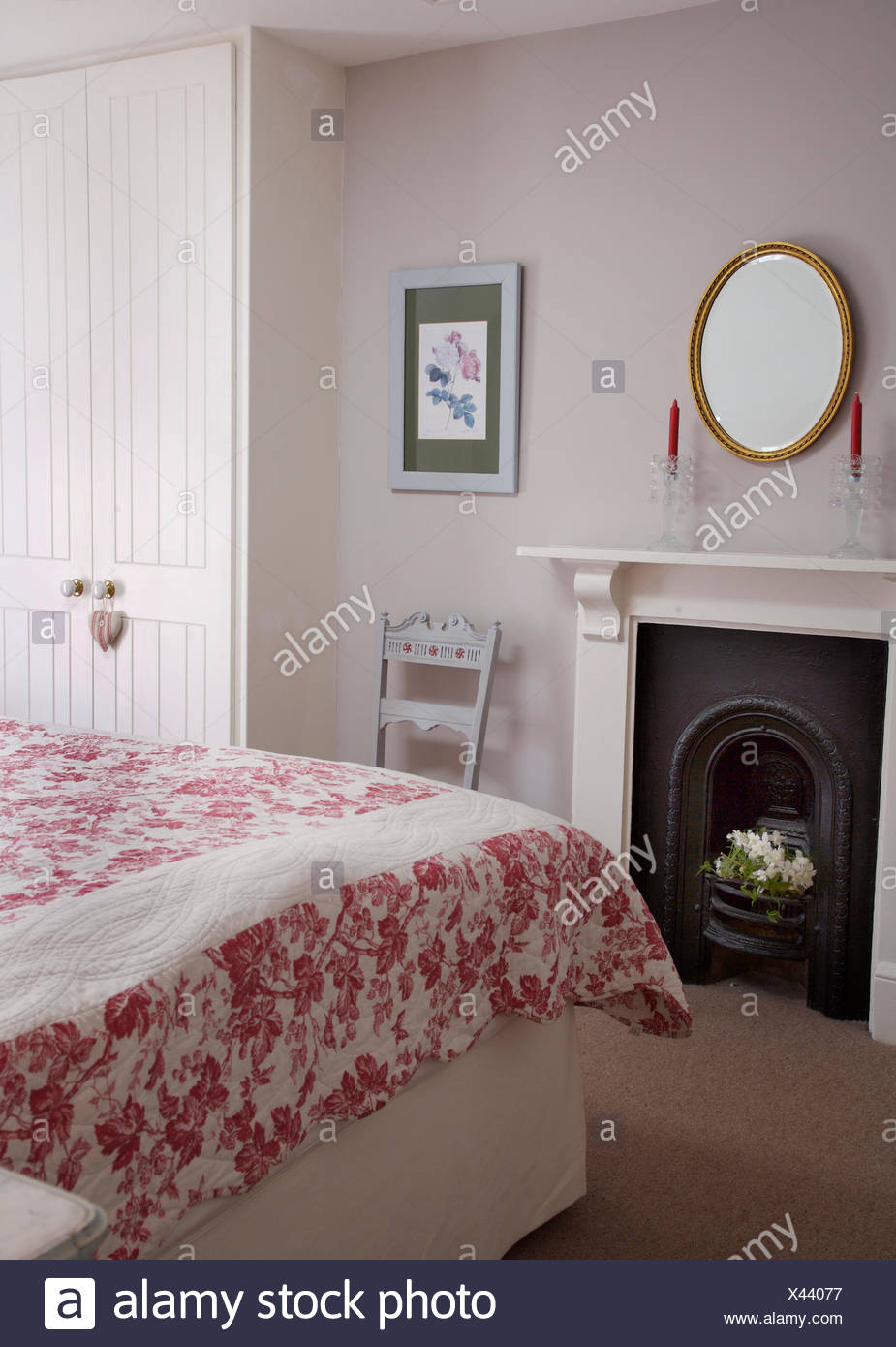 Oval Gilt Mirror Above Fireplace In Coastal Cottage Bedroom With A