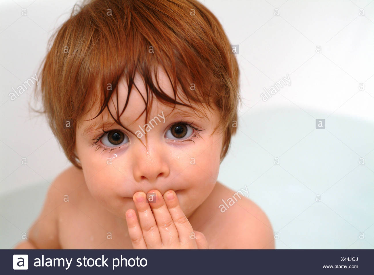 Red Haired Baby Girl With Her Fingers On Her Mouth While Taking A Bath Stock Photo Alamy