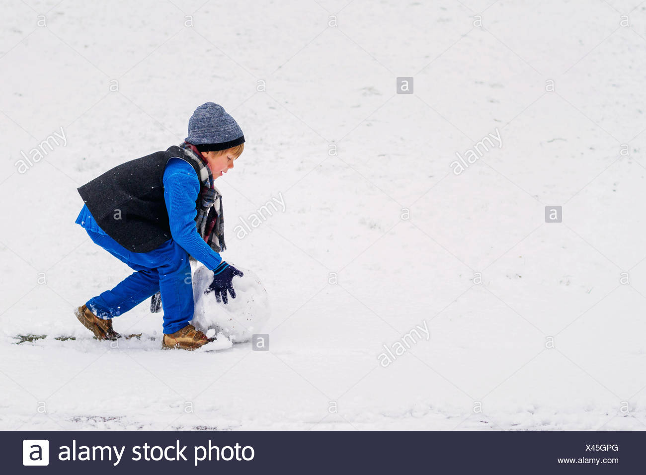 Boy rolling snow ball for making a snowman Stock Photo 277947448 Alamy