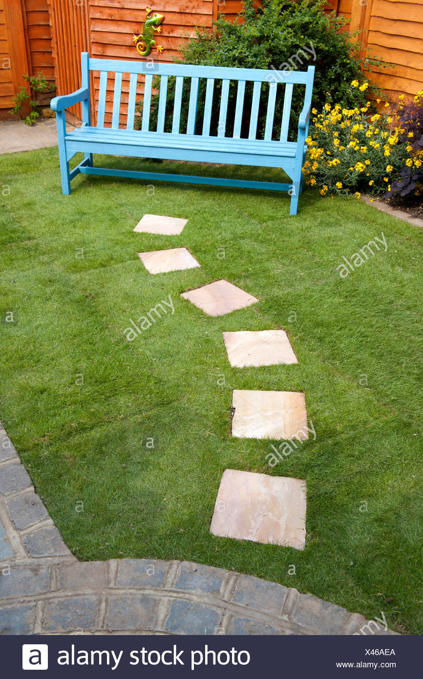 Small Garden With Stepping Stones Leading To A Bench Stock Photo