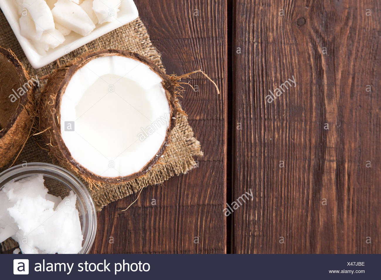 Coconut With Coconut Oil In Jar On Wooden Background Stock Photo