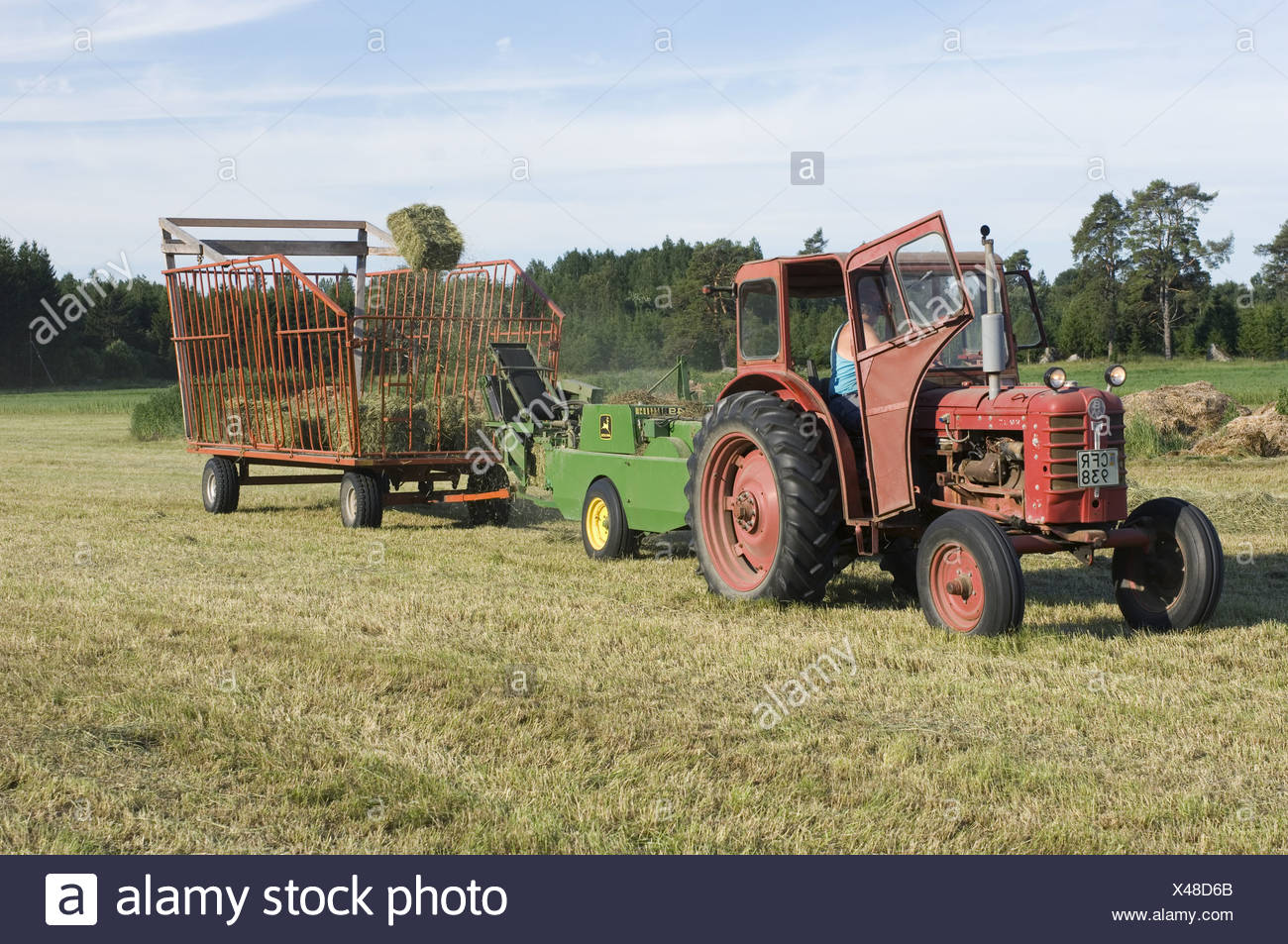 Tractor Baling Hay Crop Baler Tossing Small Bales Into Wagon Sweden Stock Photo Alamy