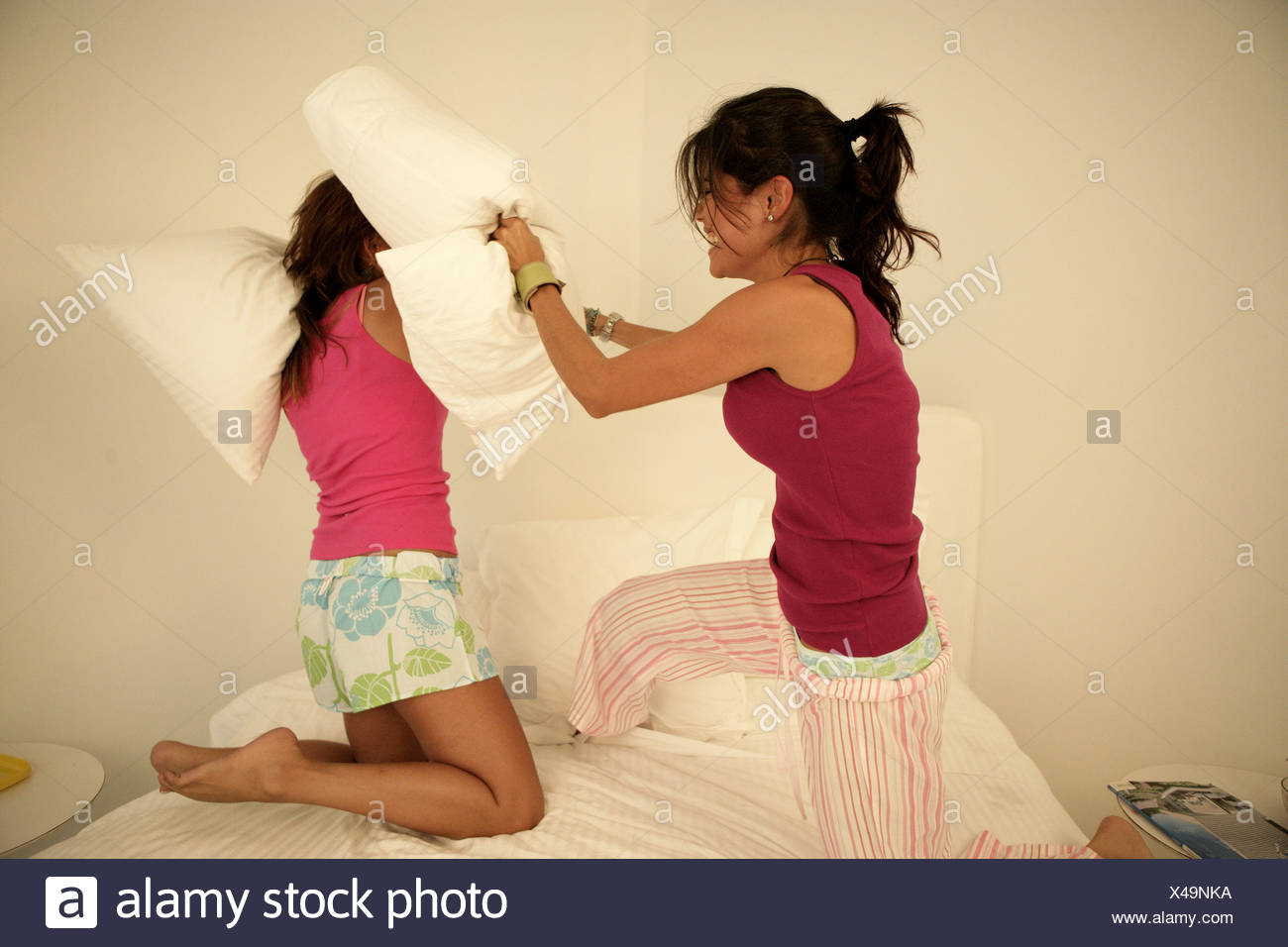 Women Pillow Fighting In Bedroom Stock Photos & Women Pillow Fighting