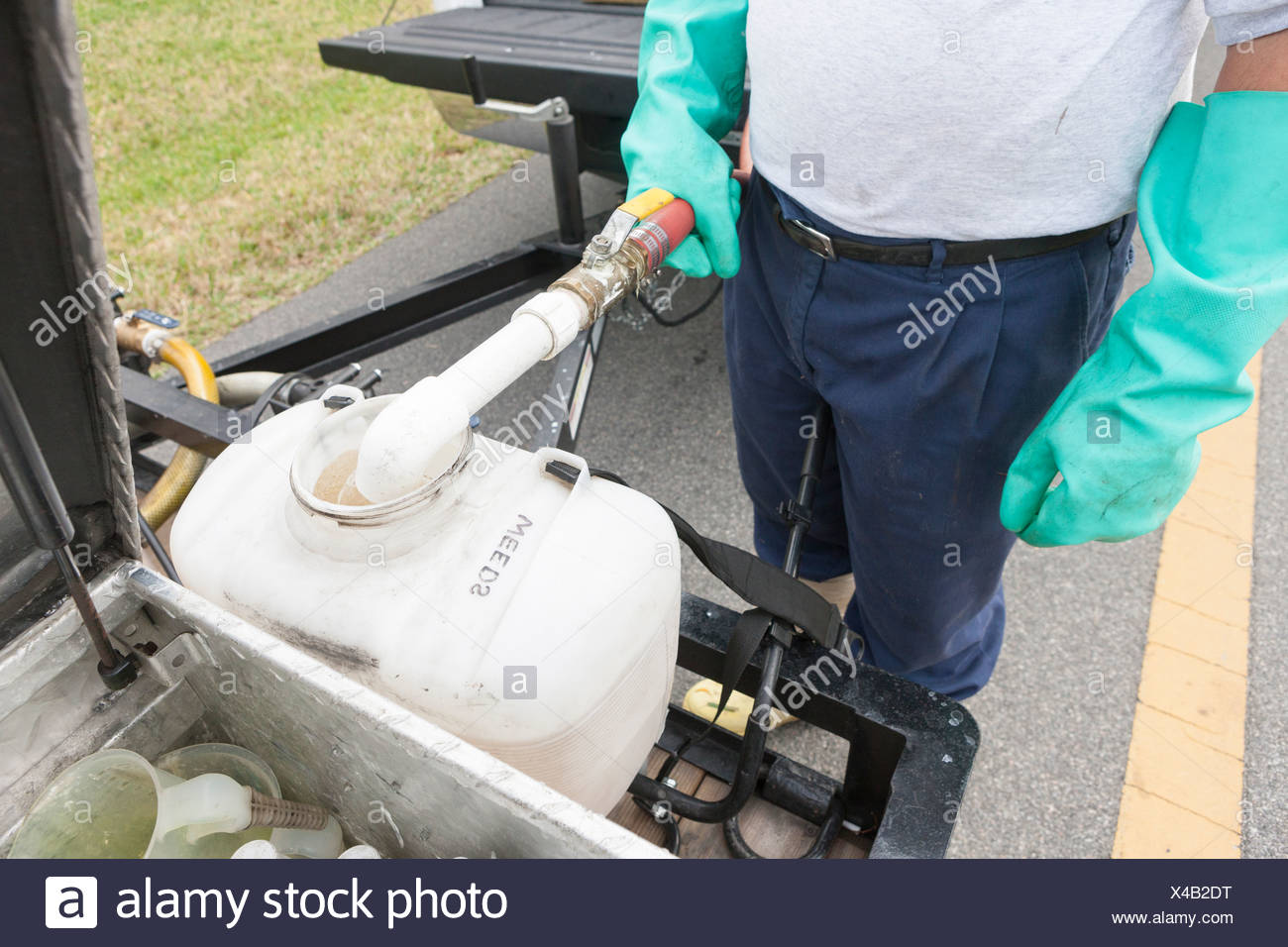 Pest Control Technician Adding Water To Chemical Container In Truck Stock Photo Alamy