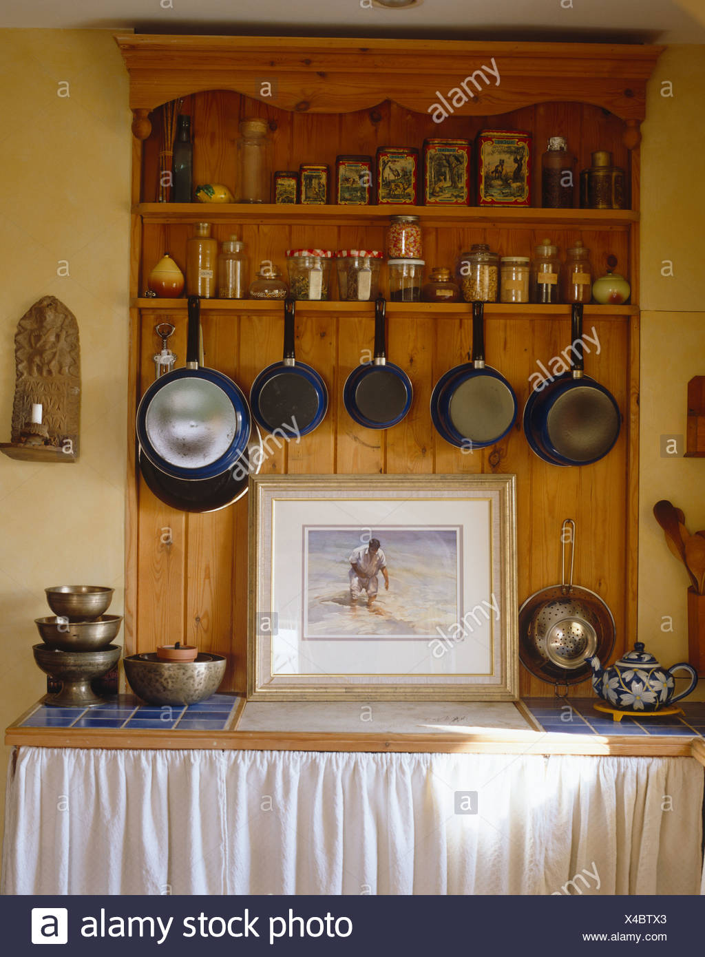 Pine Dresser With Pans Hanging On Shelf Below Storage Jars In