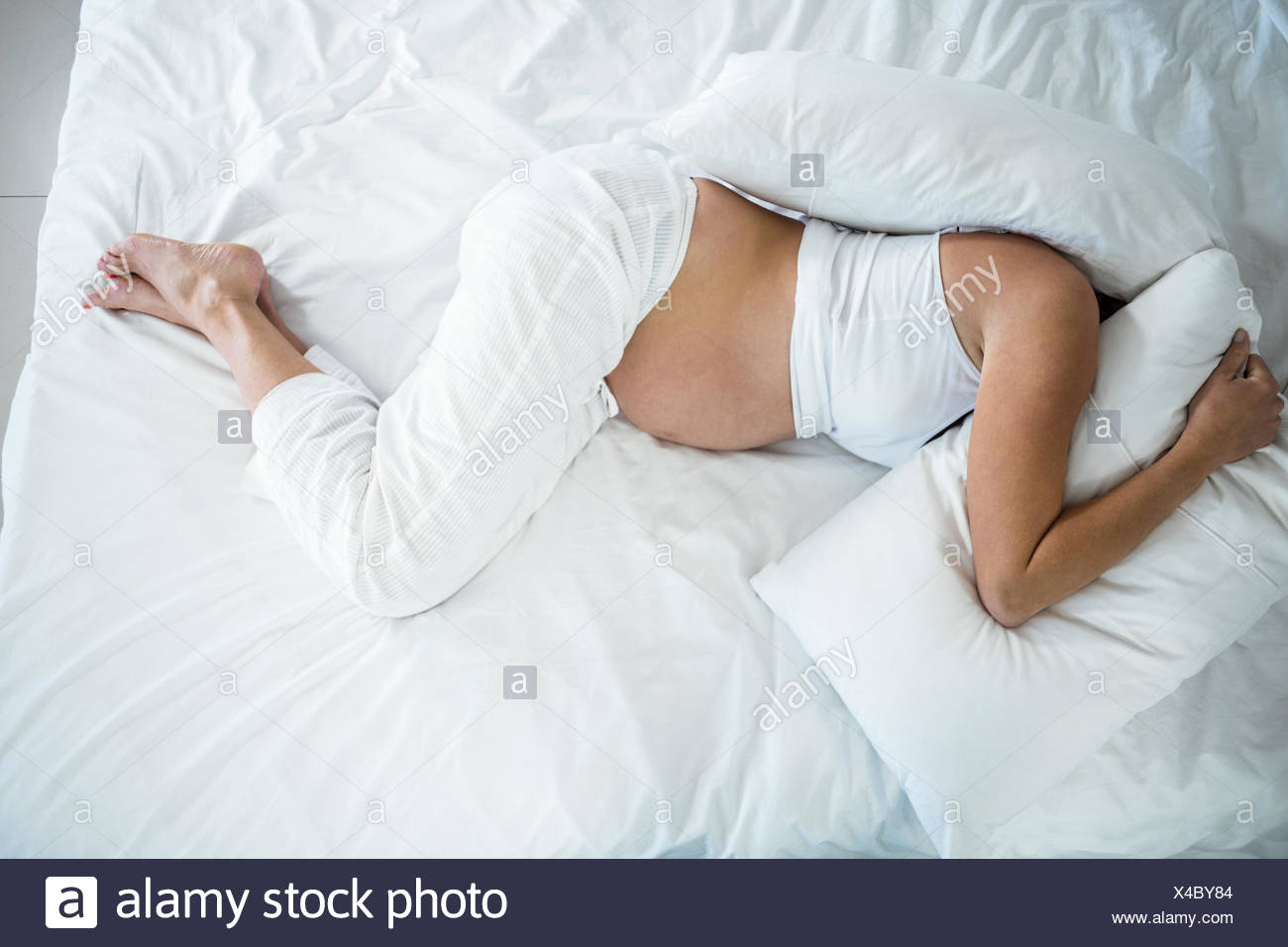 High Angle View Of Woman With Head Under Pillow Stock Photo