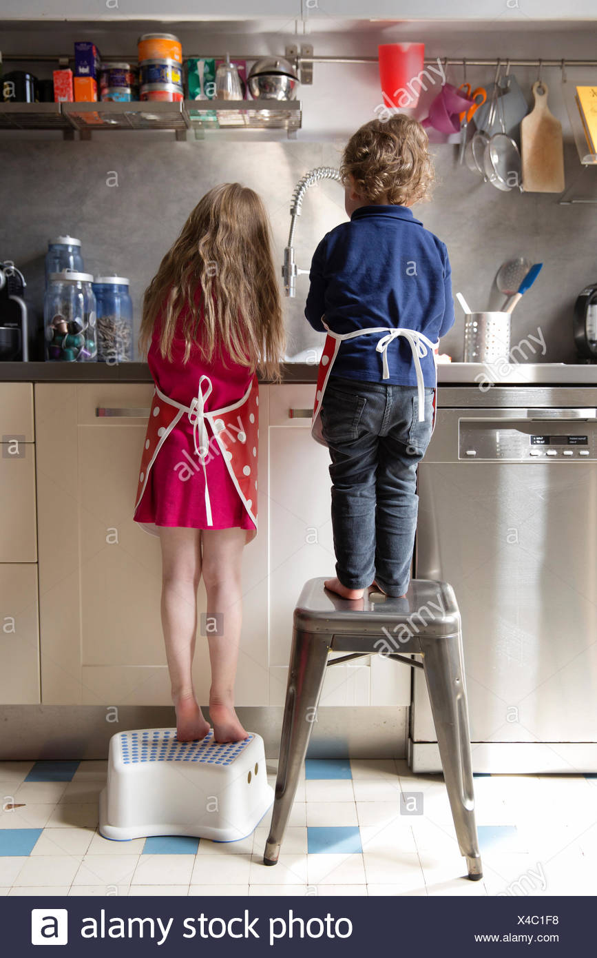 Back View Of Little Boy And Girl Washing Dishes In The Back View Of Little Boy And Girl Washing Dishes In The