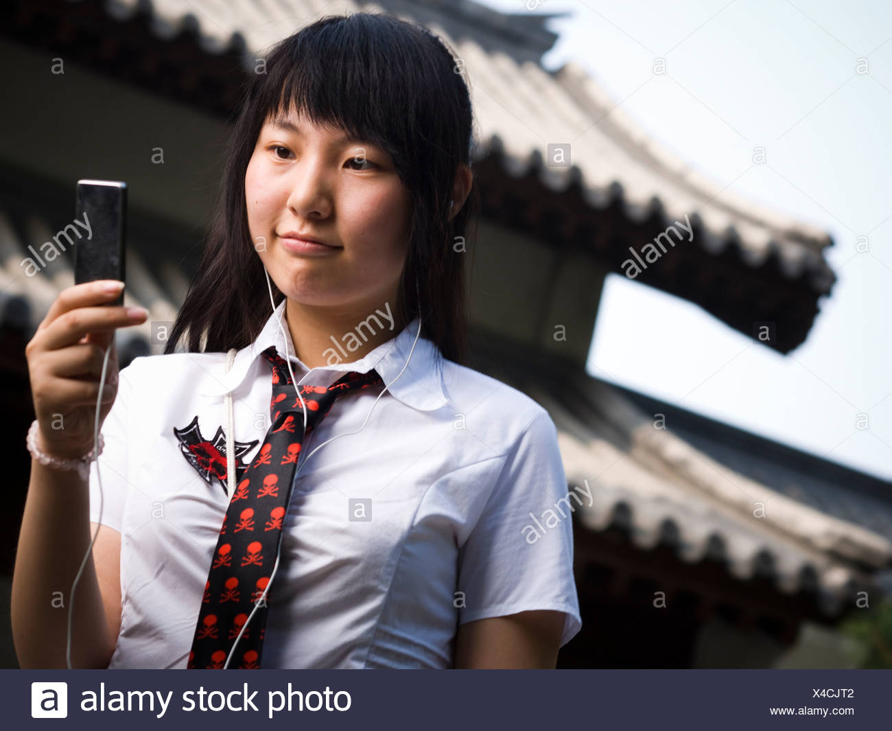 Teenage Girl In School Uniform Smiling With Mp3 Player Stock Photo