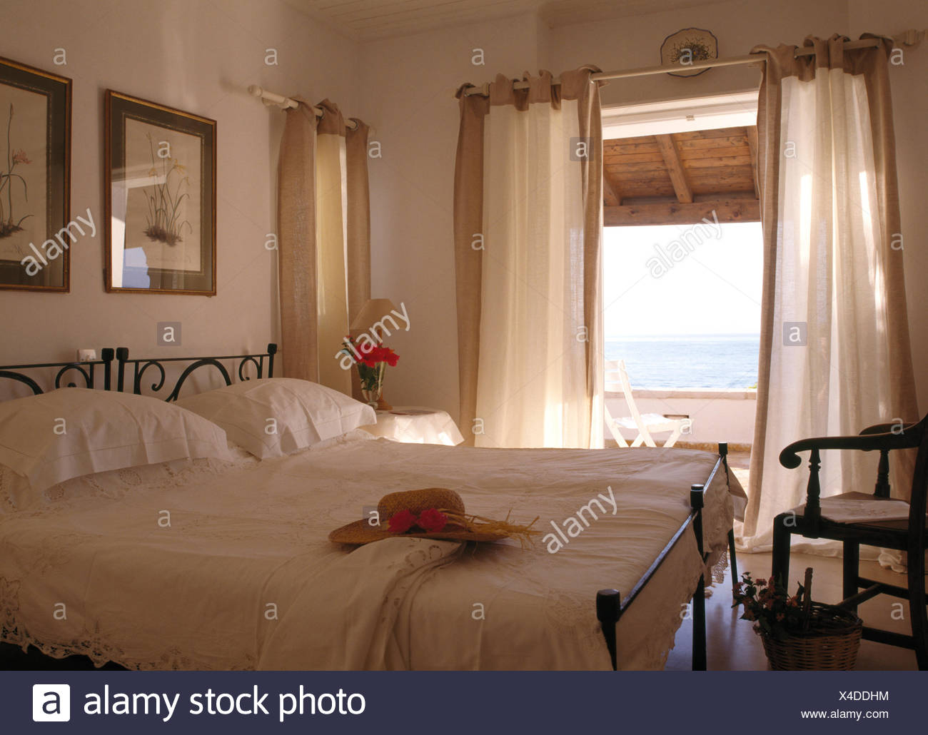 White Linen On Wrought Iron Beds In Coastal Bedroom With White