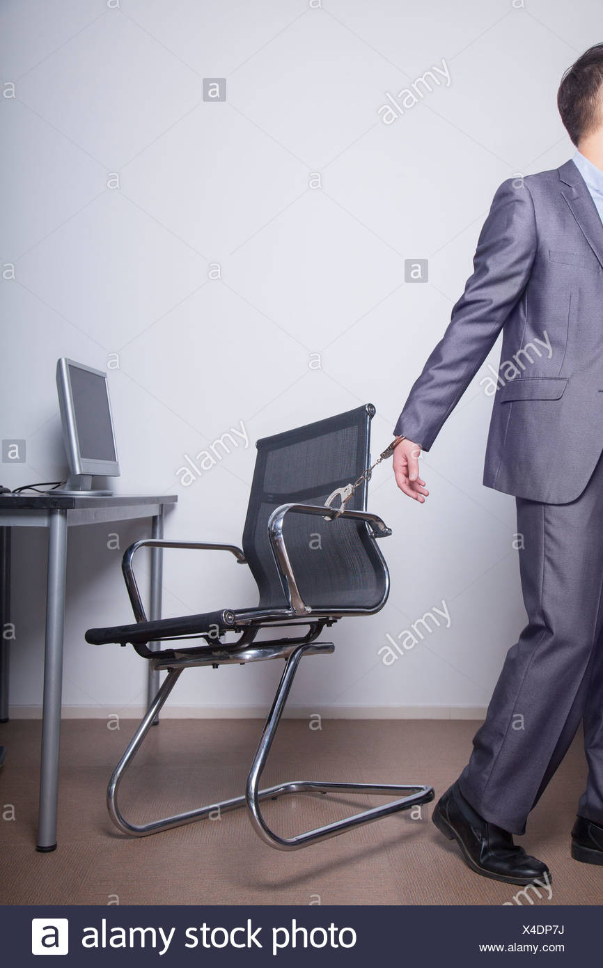 Businessman Handcuffed To His Office Chair Walking Away