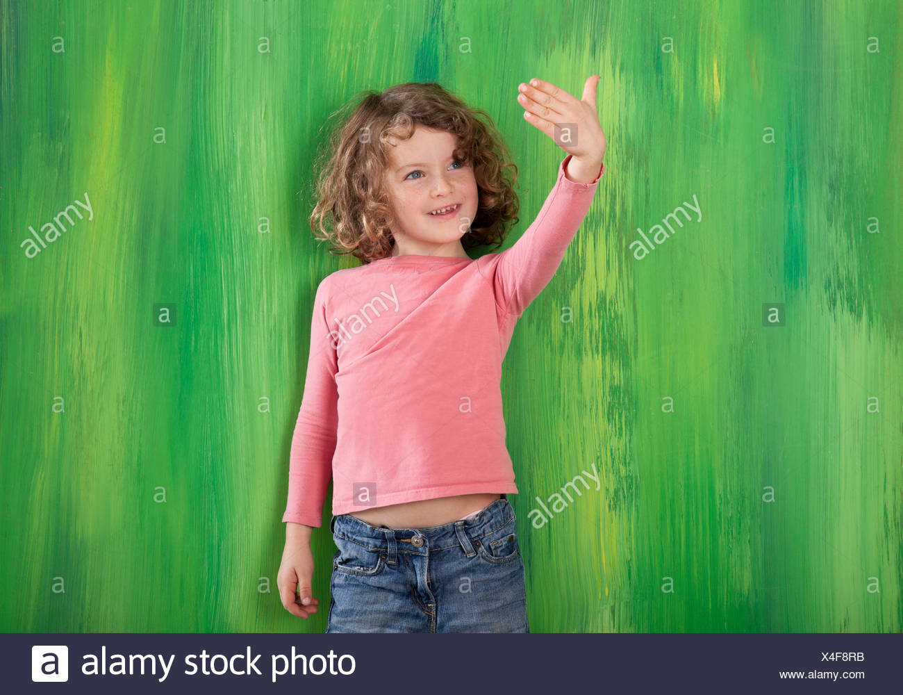 Red-haired girl, 5 years old, standing in front of a green wall Stock Photo  - Alamy