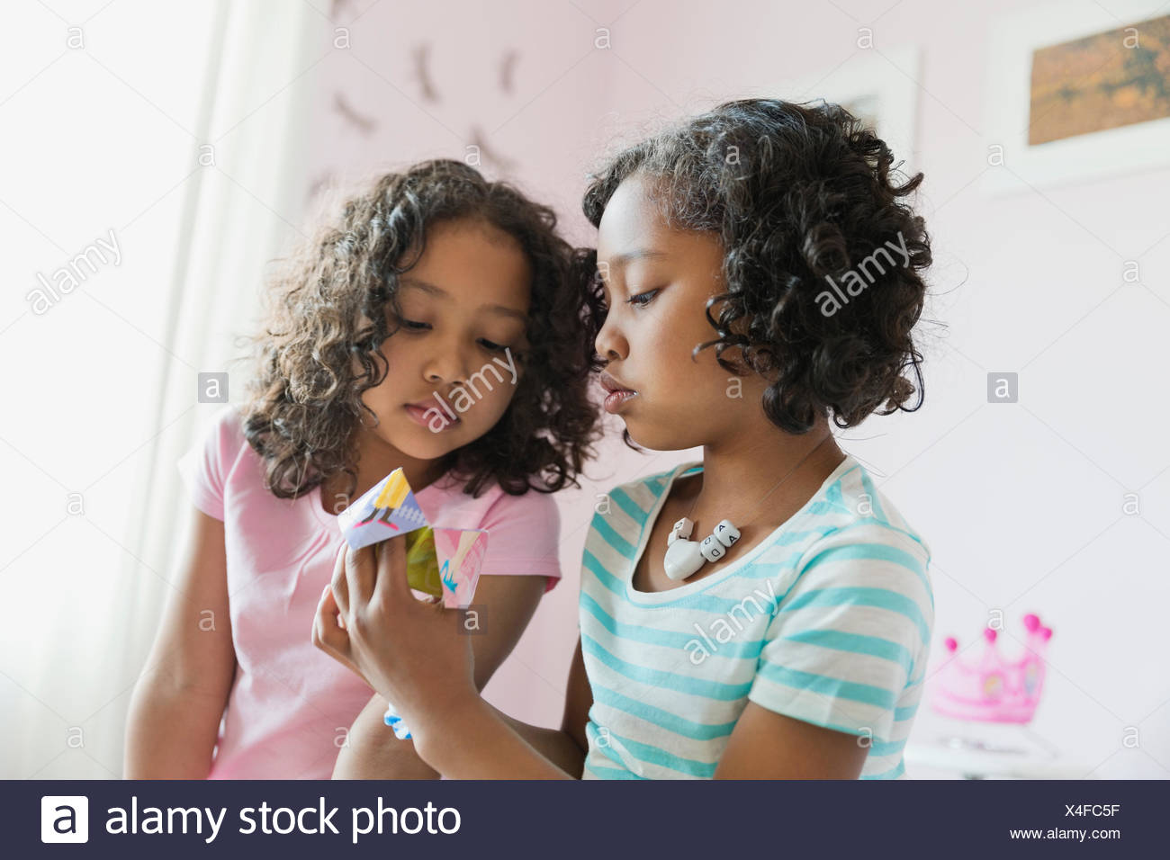Little Sisters Playing Origami Fortune Teller Game Stock