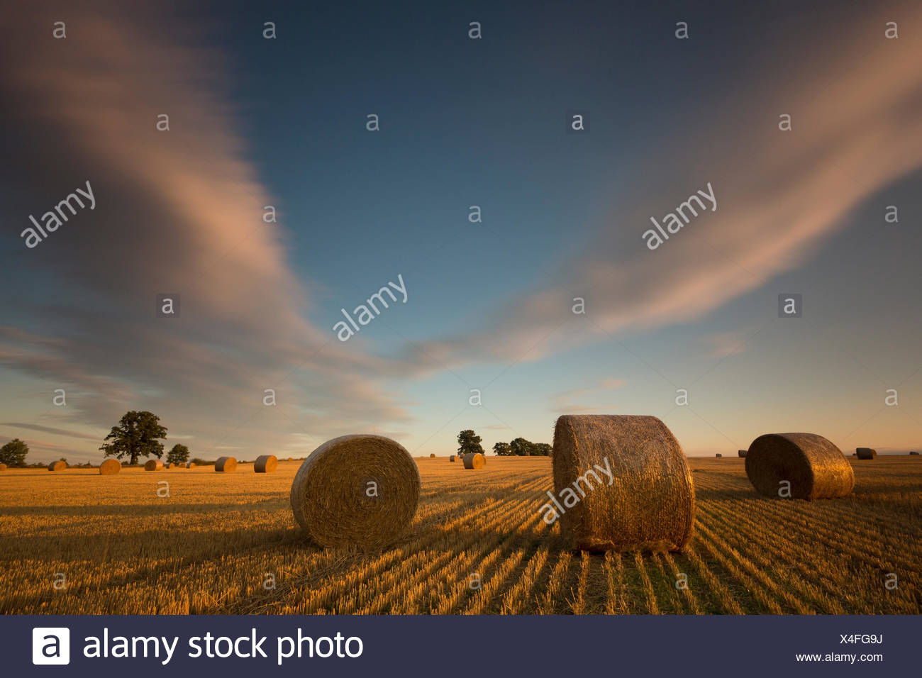 moving clouds on field with straw bales,long exposure Stock Photo